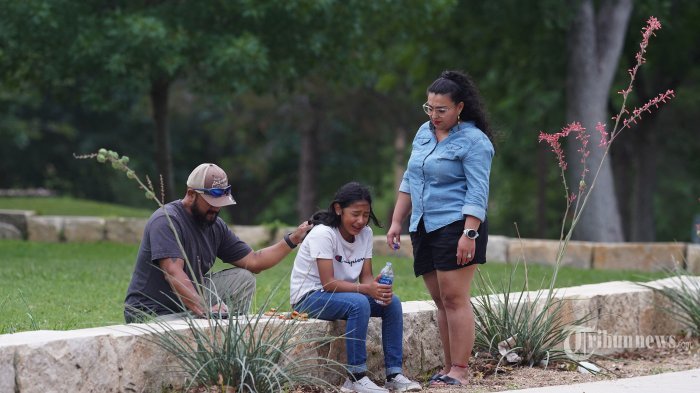 Seorang gadis menangis, dihibur oleh dua orang dewasa, di luar Willie de Leon Civic Center di mana konseling kesedihan akan ditawarkan di Uvalde, Texas, pada 24 Mei 2022. - Seorang pria bersenjata remaja membunuh 18 anak kecil dalam penembakan di sebuah sekolah dasar di Texas pada hari Selasa, dalam penembakan sekolah AS paling mematikan dalam beberapa tahun. Serangan di Uvalde, Texas -- sebuah komunitas kecil sekitar satu jam dari perbatasan Meksiko -- adalah yang terbaru dari serangkaian penembakan mematikan di Amerika, di mana kengerian pada siklus kekerasan senjata telah gagal memacu tindakan untuk mengakhirinya. (Photo by allison dinner / AFP)