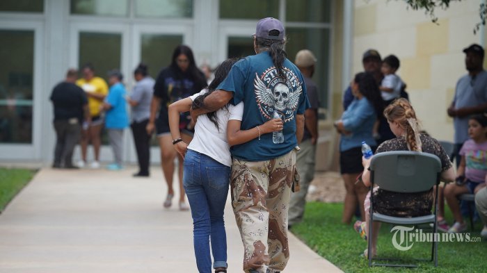 Keluarga berkumpul dan berpelukan di luar Willie de Leon Civic Center di mana konseling kesedihan akan ditawarkan di Uvalde, Texas, pada 24 Mei 2022. - Seorang pria bersenjata remaja membunuh 18 anak kecil dalam penembakan di sebuah sekolah dasar di Texas pada hari Selasa, di penembakan sekolah AS paling mematikan dalam beberapa tahun. Serangan di Uvalde, Texas -- sebuah komunitas kecil sekitar satu jam dari perbatasan Meksiko -- adalah yang terbaru dari serangkaian penembakan mematikan di Amerika, di mana kengerian pada siklus kekerasan senjata telah gagal memacu tindakan untuk mengakhirinya. (Photo by allison dinner / AFP)